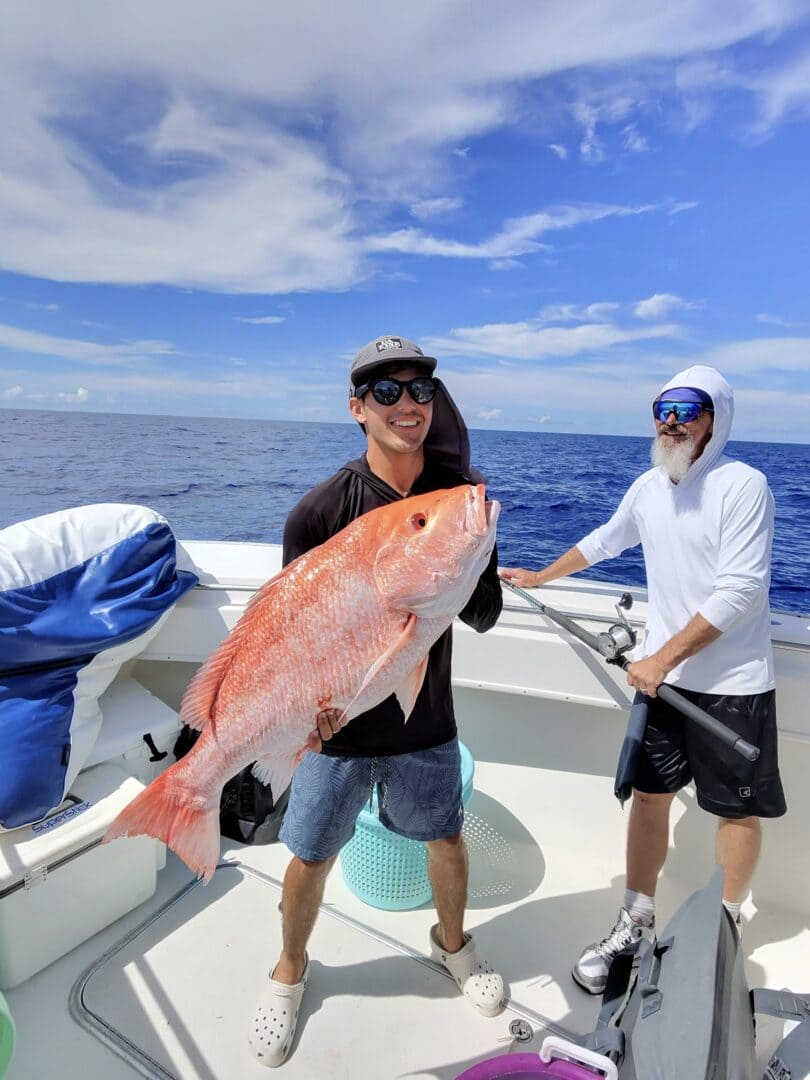 Angler holding up a large red snapper on the boat
