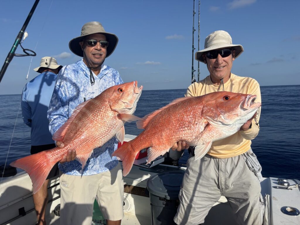 Two anglers displaying their catches on a sunny day