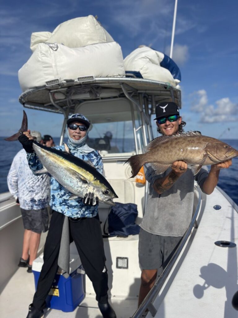 Two anglers displaying their catches aboard Salty Dog Charters