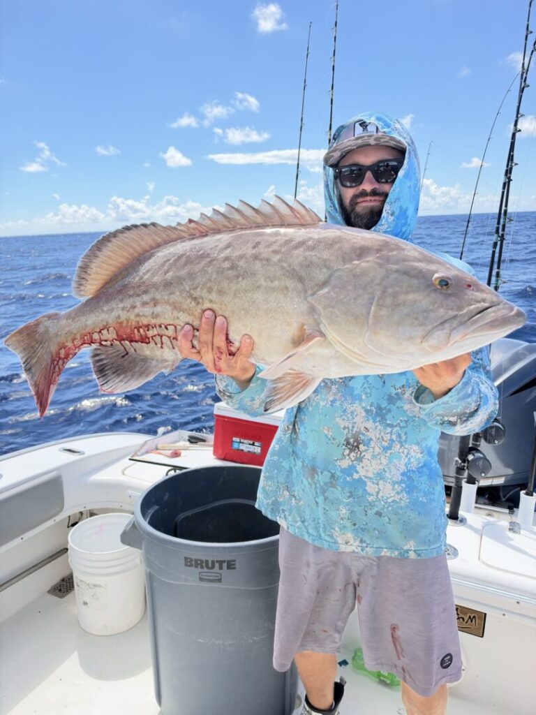Captain Brandon Vaughan holding a catch aboard his boat